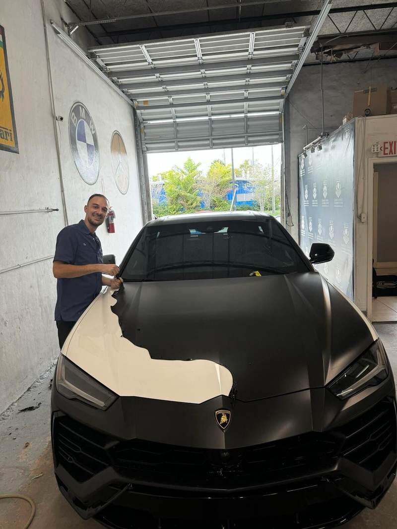 Technician working on a Lamborghini Urus at Gold Coast Collision Center